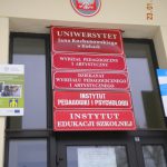 Tablica informacyjna przed wejściem do budynku uniwersytetu