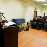 Wyróznieni absolwenci w togach, na mównicy stoi dziekan dr Jolanta Stanienda
