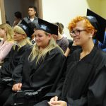 Absolwenci uczestniczący w promocji ubrani w czarne togi i birety