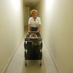 Studentka z wózkiem w hotelowym korytarzu