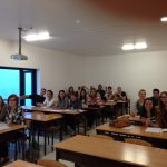 Studenci siedzący przy stolikach w sali wykładowej podczas lektoratu języka portugalskiego