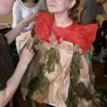 Studentka ubierama przez koleżankę w ekologiczny strój z papieru pakowego, bibuły i gałązek