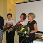 Panie Marta Falińska i Gertruda Gałek z bukietami kwiatów od władz Uczelni