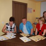 Jury podpisuje dyplomy - od lewej siedzą mgr Renata Mielak, fotograf Andrzej Tylko, dr Marzena Bac, stoi - lic. Anna Giza