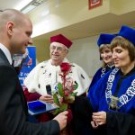 Absolwent Łukasz Łabno odbiera medal "Bene Merito"