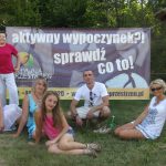 Cztery studentki z koła "Paidagogos" oraz Łukasz Słomski, w tle baner promujące aktywny wypoczynek