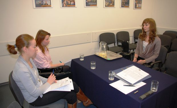 Członkowie komisji rekrutacyjnej oraz studentka w takcie rozmowy dotyczącej wyjazdu na praktykę