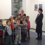 Grupa przedszkolaków z opiekunem Martę Falińską oraz kanclerz Zofia Kozioł w auli budynku przy ul. Szerokiej 9