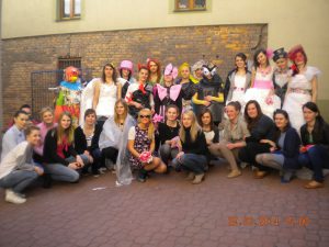 Zdjęcie grupowe - modelki w strojach oraz projaktanci na dziedzińcu budynku przy ul. Szerokiej 9