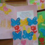 Kartki świąteczne wykonane przez dzieci. Na kartkach z zielonego i rózowego kartonu naklejone motyle kurczaki i tulipany