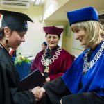 Kanclerz i dziekan Smoleń wręczają dyplom studentce