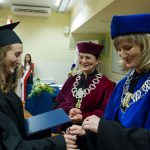 Kanclerz i dziekan Smoleń wręczają dyplom studentce
