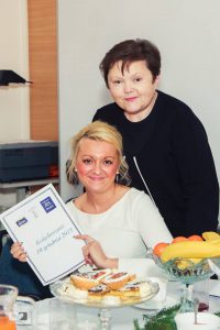 mgr Marta Falińska (siedzi, pokazując do obiektywu dyplom)i mgr Gertruda Gałek (stoi)