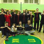 Grupa studentów stoi w sali gimnastycznej - trening Tai Chi