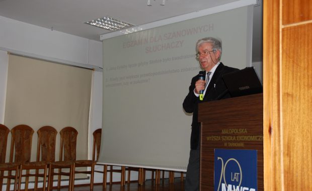 Prof. Władysław Błasiak na scenie z mikrofonem w ręce