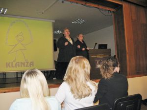Joanna Niedziałek, Barbara Ciastoń ze Stowarzyszenia Klanza stoją na scenie, obok rozwinięty ekran z prezentacją