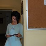 Studentka oparta o ścianę czyta notatki