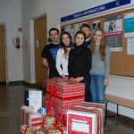 Grupa pięciorga studentów reprezentujący RUSS, przed nimi zapakowane w ozdobny papier prezenty