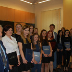 Grupa studentek oraz członkowie komisji egzaminacyjnej na wspólnym zdjęciu